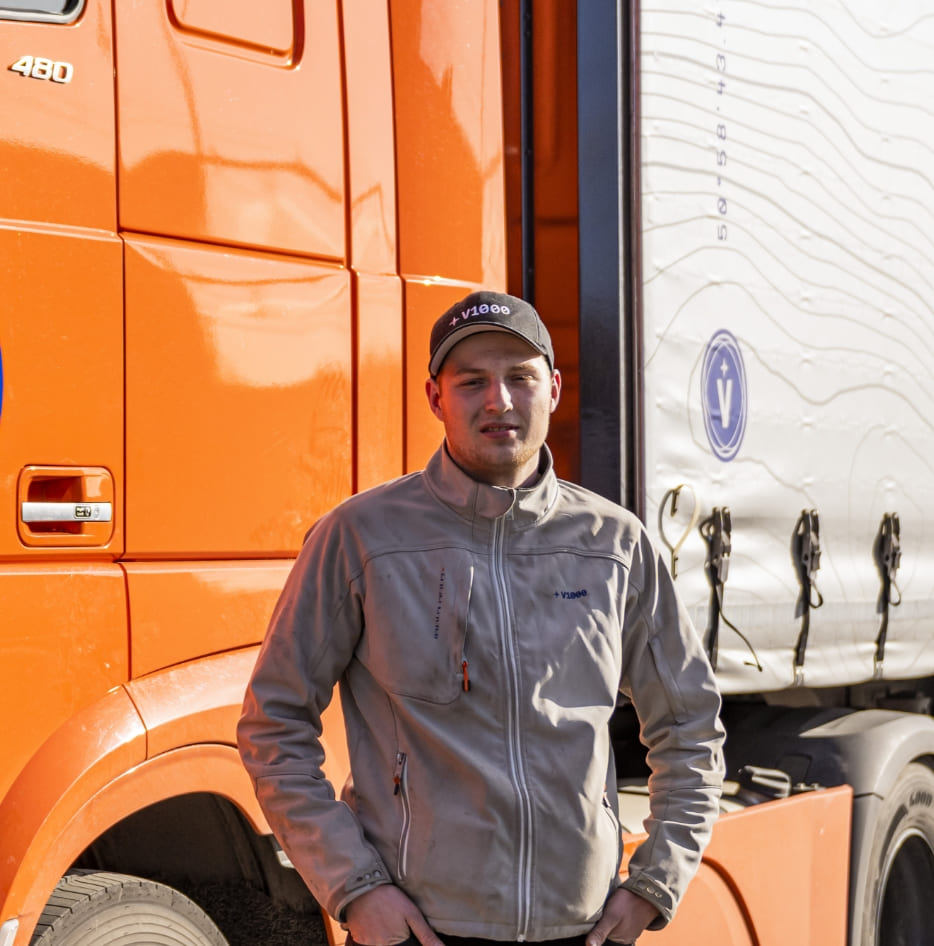 Afbeelding van werknemer bij oranje vrachtwagen